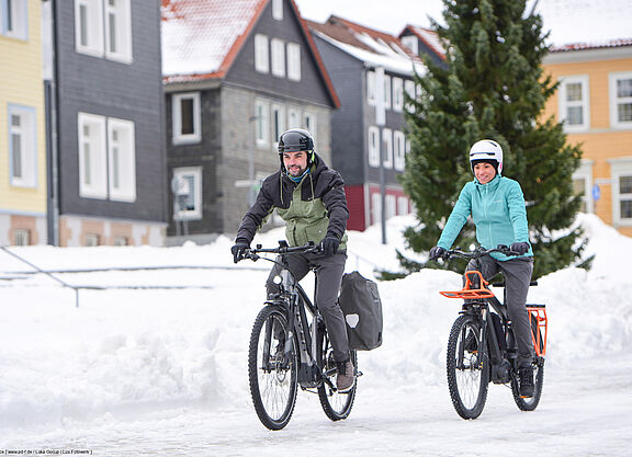 Aufmacher Gesehen und Gefahren Zwei Radfahrende in verschneiter Stadt.